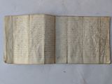 an old book with writing on it sitting on top of a table