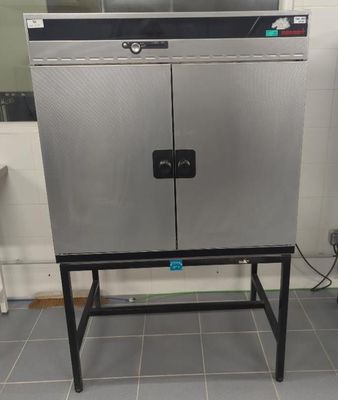 a stainless steel cabinet in the middle of a tiled floor