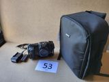 un appareil photo et un sac posé par terre à côté