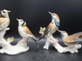 trois figurines d'oiseaux perchés sur une branche d'arbre