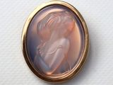 an image of a picture of a woman in a pink dress is shown in a gold locke