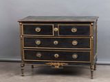 an image of a black and gold chest of drawers against a gray wall