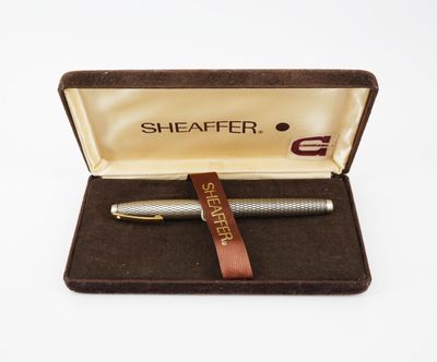 un stylo dans une boîte munie d'une lanière en cuir