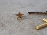 a small gold star on the ground next to a pair of scissors