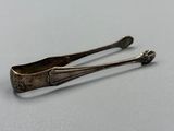 une paire de cuillères anciennes en argent posées sur une surface blanche