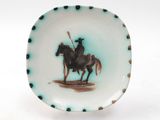 a plate with a picture of a man riding a horse