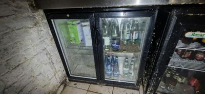 a refrigerator that has two bottles of beer inside of it