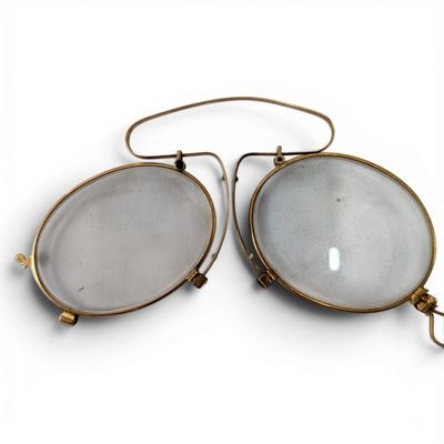 pair of antique brass and glass eyeglasses on a white background