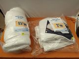 deux rouleaux de papier toilette emballés dans du plastique, posés sur une table