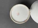 a close up of a white cup and saucer on a table