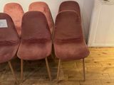 four pink chairs are lined up against a wall in a room