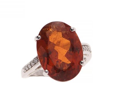 une bague sertie d'un saphir orange de taille ovale et de diamants