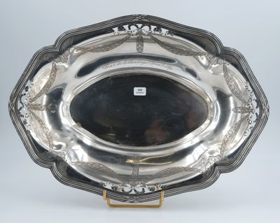 an antique silver plate with a decorative design on a stand
