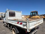 a white truck with a bulldozer in the back of it