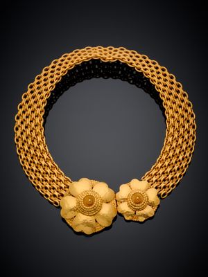 un collier en or avec des fleurs sur une chaîne