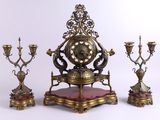 a clock that is sitting on a stand next to other items