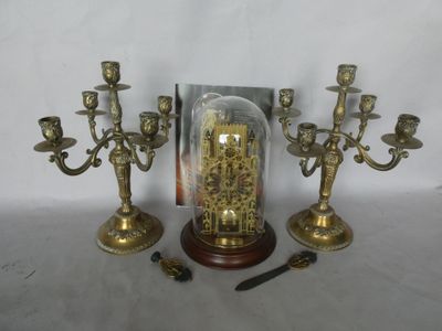 three brass candelabs with a glass dome on top of them