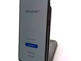 a close up of a cell phone on a stand on a white surface