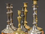 three silver candles are sitting on top of a wooden table