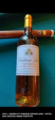 une bouteille de vin posée à côté d'un cigare sur une table de billard