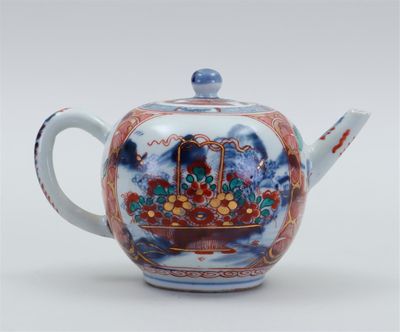 une théière orientale ornée d'un panier de fleurs