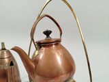 a copper teapot and a copper kettle on a stand