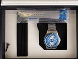 a watch in a box with a pen and a watch strap