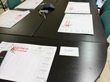 une longue table sur laquelle sont posés des papiers et une télécommande