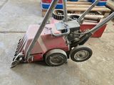 a small red machine that is sitting on the ground
