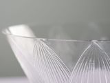 a clear glass bowl with a curved design on it