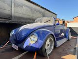 a blue vw beetle parked on the side of the road