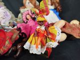 many dolls that are sitting together on a black surface