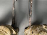 pair of antique brass lion head hooks on a silver background