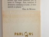 un vieux livre à la couverture rouge et blanche posé sur une surface blanche
