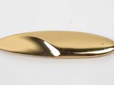 a close up of a gold colored object on a white surface