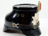 a black hat with a leaf on it on a white surface