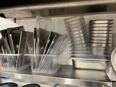 de nombreux récipients et casseroles sur l'étagère de la cuisine