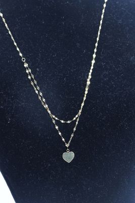 un collier avec un pendentif en forme de cœur autour du cou d'un mannequin