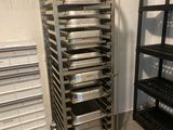 Plusieurs plateaux de nourriture sont empilés sur un chariot dans une cuisine