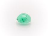 a close up of a green stone on a white surface