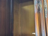 a wooden cabinet with a door open and a red carpet underneath it