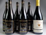 six bottles of wine are lined up on a table