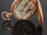 an image of a close up of a pocket watch on a reflective surface