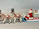 une figurine représentant le Père Noël dans un traîneau tiré par des rennes