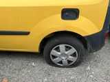 a small yellow car parked on the side of the road