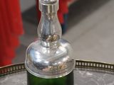 a green glass bottle sitting on top of a metal tray