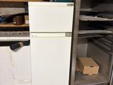 a refrigerator in the middle of a dirty kitchen