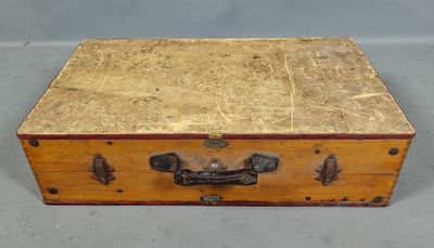 une petite boîte en bois munie d'une poignée en métal, posée sur une table