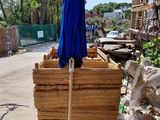 a blue umbrella sitting on top of a pile of wood