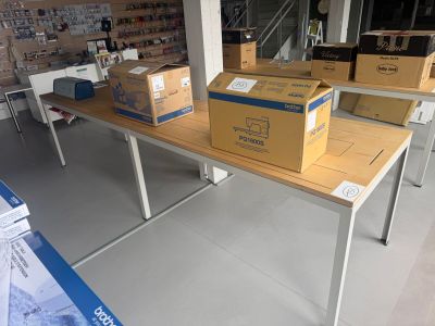 Plusieurs cartons sont empilés sur une table dans une pièce.